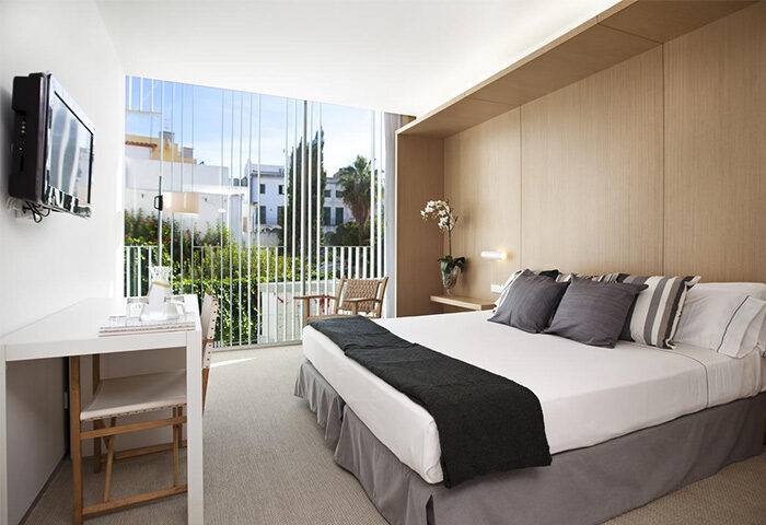 Alenti Sitges Hotel & Restaurant room. Gay-friendly hotel with balcony, bed, desk, and TV. Modern design for gay travelers in Sitges, Spain.