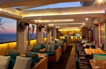 Alexander Tel Aviv Hotel's gay-friendly bar. Stylish seating, ocean views, and a well-lit bar create an inviting atmosphere. Perfect for gay travelers.