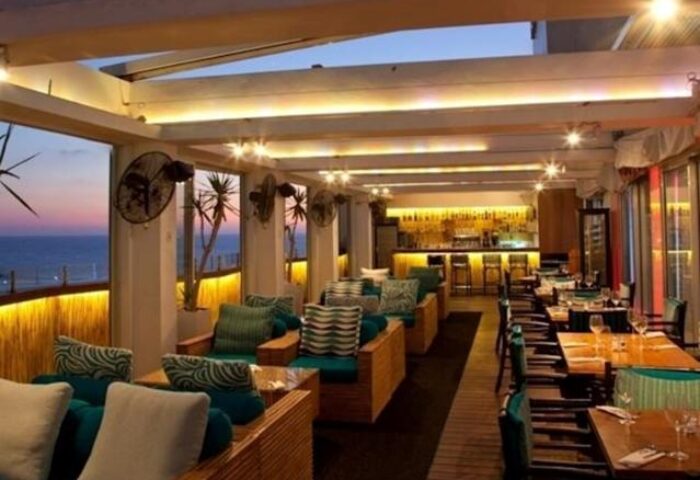 Alexander Tel Aviv Hotel's gay-friendly bar. Stylish seating, ocean views, and a well-lit bar create an inviting atmosphere. Perfect for gay travelers.