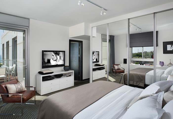 Alexander Hotel Tel Aviv room. Gay-friendly hotel featuring a modern bedroom with mirrored closet, balcony, and TV. Ideal for gay travel.