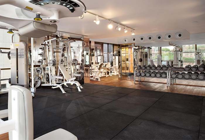 Gym at Alexander Tel Aviv Hotel, a gay-friendly hotel. Fitness center with weights, machines, and mirrors. Perfect for gay men's travel.