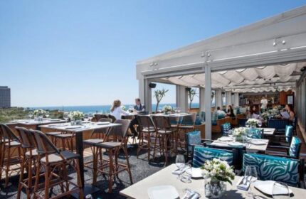 Alexander Tel Aviv Hotel's gay-friendly rooftop restaurant. Tables are set with flowers, overlooking the sea. A great spot for gay travelers.