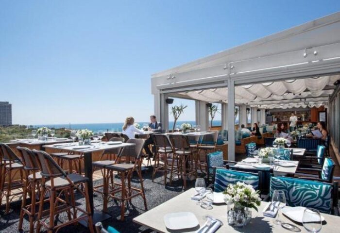 Alexander Tel Aviv Hotel's gay-friendly rooftop restaurant. Tables are set with flowers, overlooking the sea. A great spot for gay travelers.