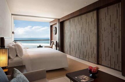 Alila Seminyak gay-friendly hotel room. Ocean view from bed. Modern design, wood accents, and luxury amenities. Bali gay travel.