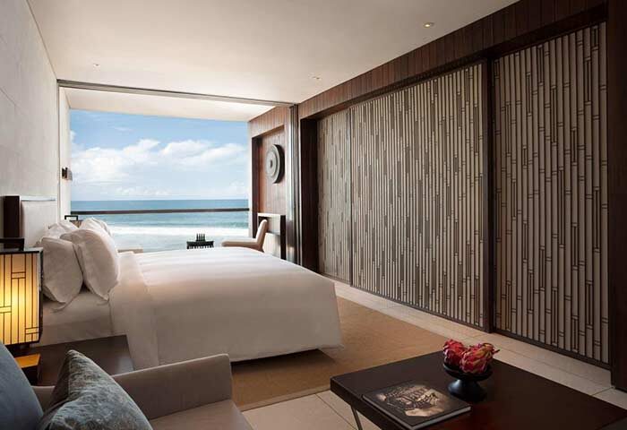 Alila Seminyak gay-friendly hotel room. Ocean view from bed. Modern design, wood accents, and luxury amenities. Bali gay travel.