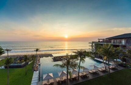 Alila Seminyak: Gay-friendly hotel view at sunset. Pool, beach, and modern architecture. A luxury travel destination for gay men in Bali.