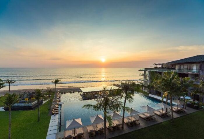 Alila Seminyak: Gay-friendly hotel view at sunset. Pool, beach, and modern architecture. A luxury travel destination for gay men in Bali.