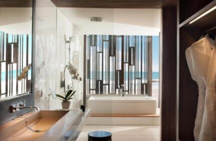 Alila Seminyak's luxurious bathroom with ocean view. This gay-friendly hotel offers a stylish retreat in Bali. Modern design, bathtub, robes.
