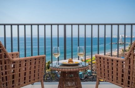 Almar Resort LGBT beachfront view. Adults-only luxury gay-friendly hotel balcony with drinks, ocean view, and beach in Puerto Vallarta.