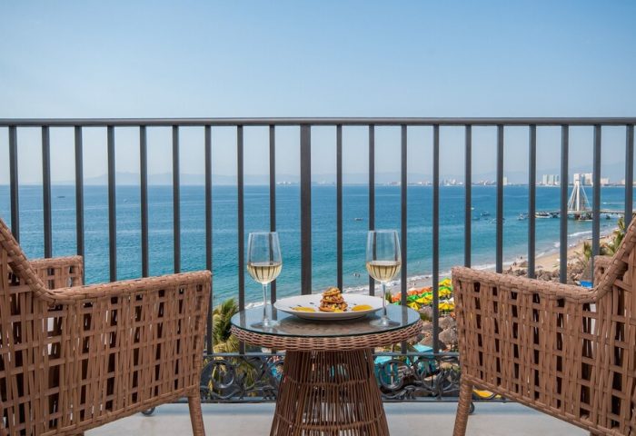 Almar Resort LGBT beachfront view. Adults-only luxury gay-friendly hotel balcony with drinks, ocean view, and beach in Puerto Vallarta.