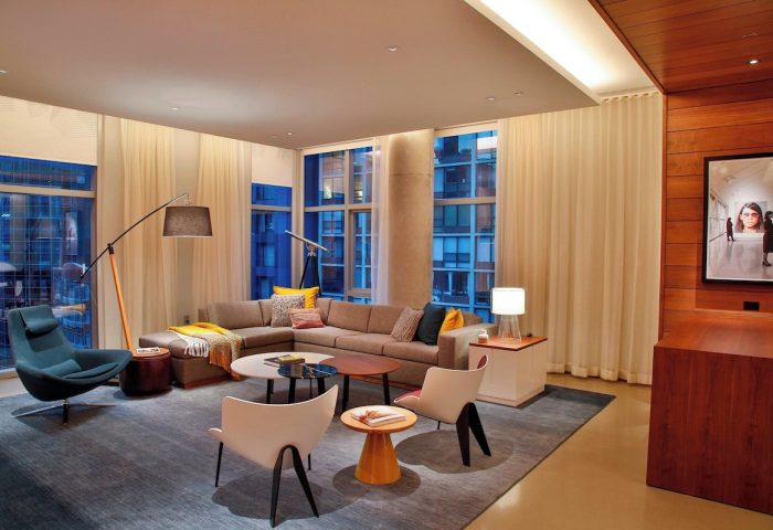 Aloft Chicago Mag Mile's stylish suite. Gay-friendly hotel with modern decor, sectional sofa, and city views. Ideal for LGBTQ+ travelers.