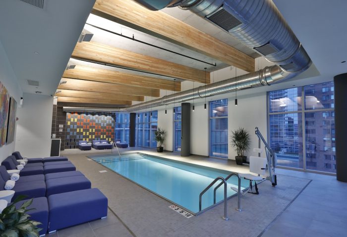 Indoor pool at Aloft Chicago Mag Mile, a gay-friendly hotel. Lounge chairs, city views, and accessible features. A relaxing space for travelers.