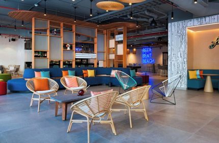 Aloft Playa del Carmen's stylish lounge area. Gay-friendly hotel with colorful decor, modern seating, and a vibrant atmosphere. Perfect for LGBT travelers.