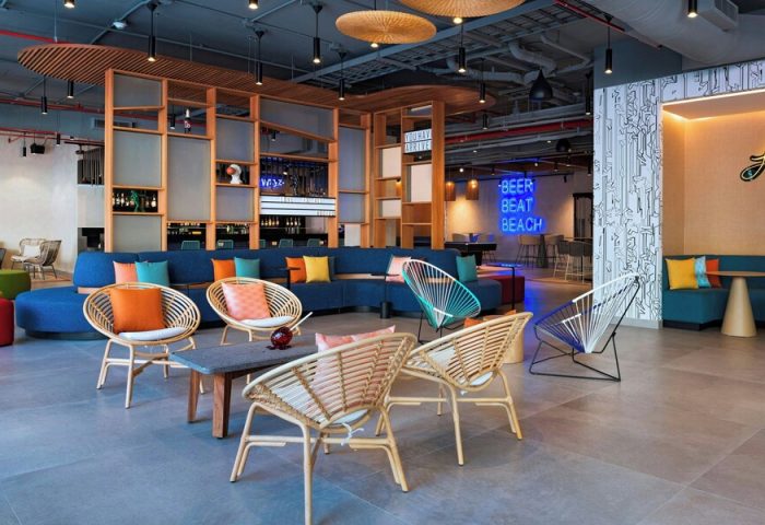 Aloft Playa del Carmen's stylish lounge area. Gay-friendly hotel with colorful decor, modern seating, and a vibrant atmosphere. Perfect for LGBT travelers.
