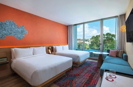 Aloft Playa del Carmen gay-friendly hotel room. Two beds, colorful rug, and modern decor. A great hotel choice for gay travelers.