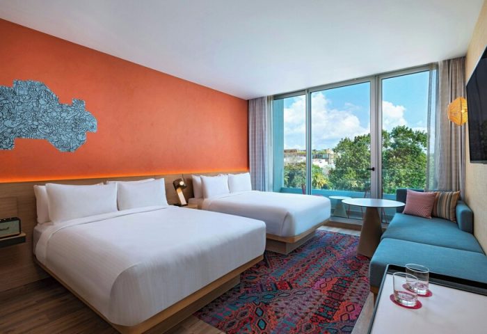 Aloft Playa del Carmen gay-friendly hotel room. Two beds, colorful rug, and modern decor. A great hotel choice for gay travelers.