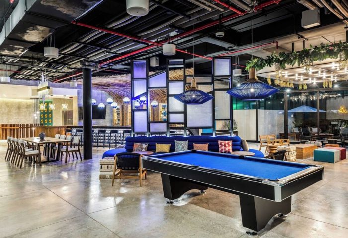 Aloft Tulum, a gay-friendly hotel. Interior view of the hotel lobby with a pool table, bar, and seating areas. Modern design and decor.