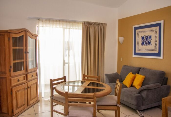 Amapas Apartments Puerto Vallarta living area. Gay-friendly hotel with dining table, sofa, and cabinet. Comfortable vacation rental in PV, Mexico.