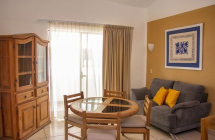 Amapas Apartments Puerto Vallarta living area. Gay-friendly hotel with dining table, sofa, and cabinet. Comfortable vacation rental in PV, Mexico.