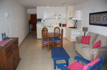 Amapas Apartments Puerto Vallarta: Living area and kitchen in a gay-friendly hotel. Cozy, well-lit space with dining table, sofa, and kitchenette.