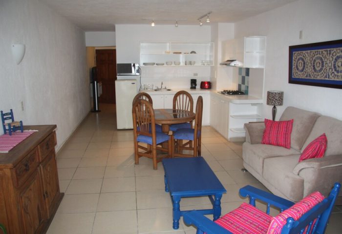 Amapas Apartments Puerto Vallarta: Living area and kitchen in a gay-friendly hotel. Cozy, well-lit space with dining table, sofa, and kitchenette.