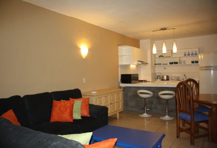Amapas Apartments Puerto Vallarta living space. Gay-friendly hotel with kitchen, bar stools, couch, and dining table. Interior design.