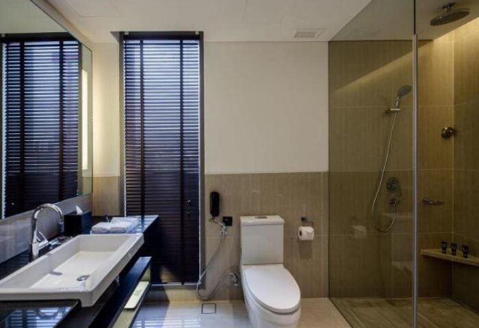 Bathroom at Amara Bangkok Hotel, a gay-friendly hotel. Features a modern sink, toilet, and shower. Great for gay travelers in Bangkok.