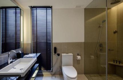 Bathroom at Amara Bangkok Hotel, a gay-friendly hotel. Features a modern sink, toilet, and shower. Great for gay travelers in Bangkok.