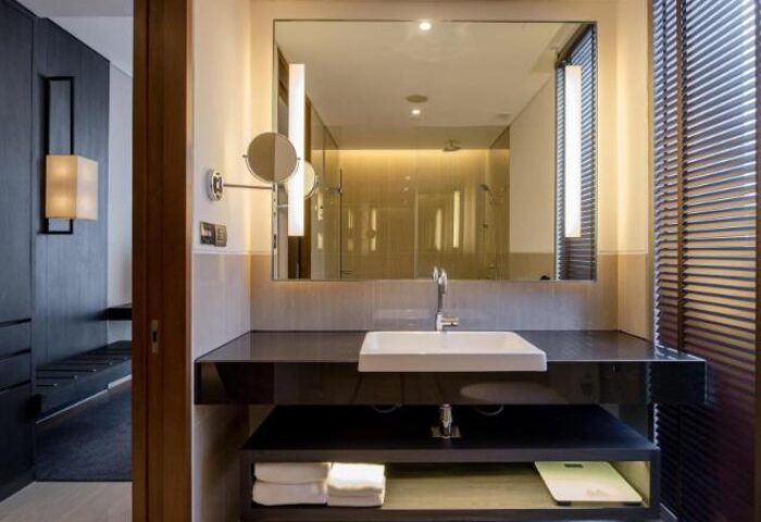 Bathroom at Amara Bangkok Hotel, a gay-friendly hotel. Features a large mirror, modern sink, and sleek design. Perfect for gay travelers.
