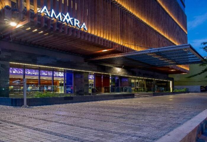 Amara Bangkok Hotel entrance at dusk. Gay-friendly hotel with modern design. Ideal for gay travelers seeking comfort in Bangkok, Thailand.