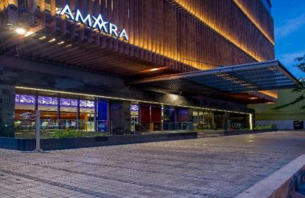 Amara Bangkok Hotel entrance at dusk. Gay-friendly hotel with modern design. Ideal for gay travelers seeking comfort in Bangkok, Thailand.