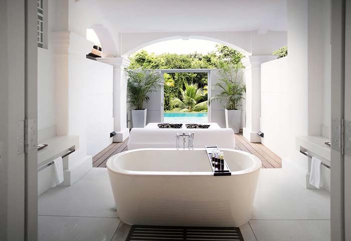 Bathroom at Amara Sanctuary Resort Sentosa, a gay-friendly hotel in Singapore. Bathtub, bed, & pool view. SG Clean Certified.