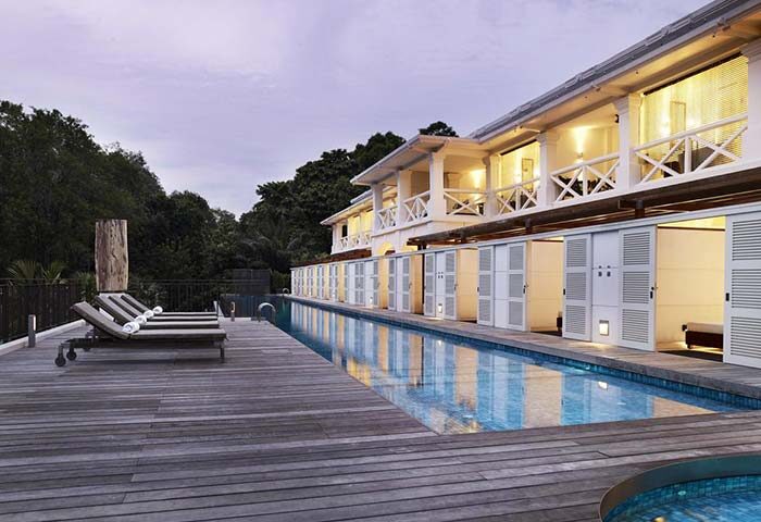 Amara Sanctuary Resort Sentosa pool view. Gay-friendly hotel with SG Clean certification. Deck chairs by the pool. Ideal for gay travel.