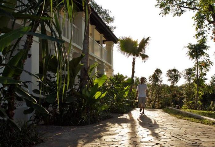 Amara Sanctuary Resort Sentosa: Gay traveler walks along the stone path. Lush greenery surrounds this SG Clean Certified, gay-friendly hotel.
