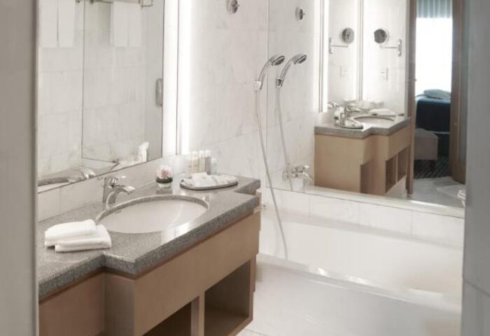 Amara Singapore gay-friendly hotel bathroom. Countertop with sink, towels, and toiletries. Bathtub and shower. A comfortable space for gay travelers.