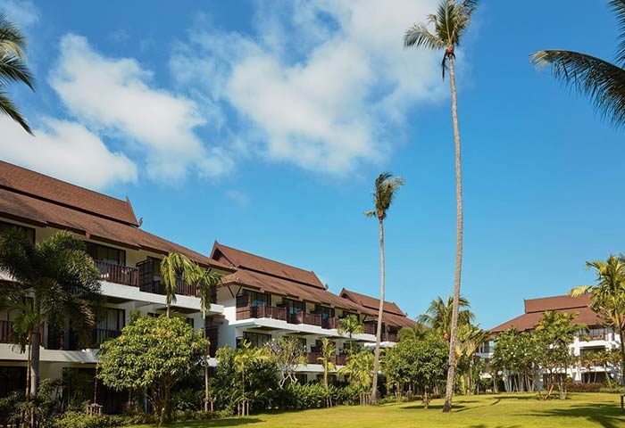 Amari Koh Samui gay-friendly hotel view. Tropical resort architecture, palm trees, blue sky. Ideal for gay travel in Koh Samui, Thailand.