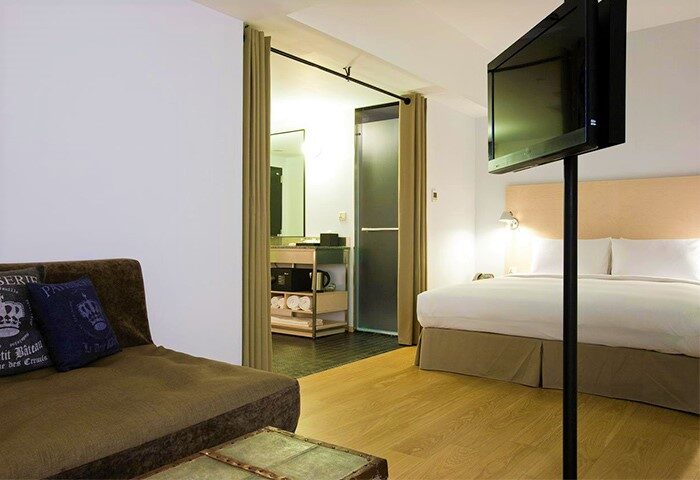 Amba Taipei Ximending Gay-Friendly Hotel room. Features a bed, sofa, TV, and bathroom. Ideal for gay travelers seeking style & comfort.