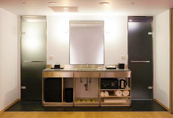 Amba Taipei Ximending hotel bathroom. Modern design with sink, mirror, shower doors, and amenities. Gay-friendly hotel in Taipei, Taiwan.