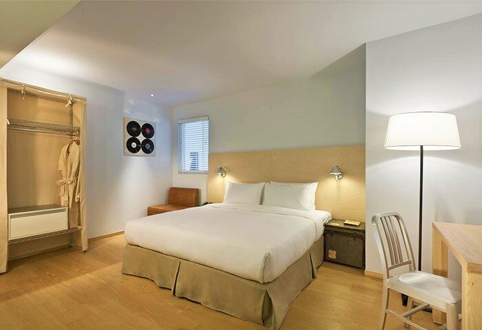 Amba Taipei Ximending gay-friendly hotel room. Queen bed, desk, closet, and decor. Modern design, comfortable for gay travelers in Taipei's Ximending.