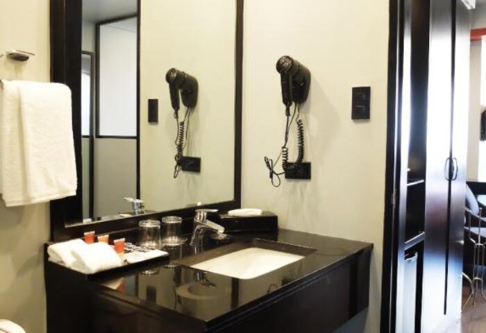 Amelie Hotel Manila bathroom. Modern sink, mirror, and hair dryer. Gay-friendly hotel room detail. Interior of a Manila hotel room.