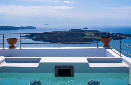 Amelot Art Suites gay-friendly hotel jacuzzi view. Santorini caldera backdrop. Luxury travel for gay men. Relaxing vacation.