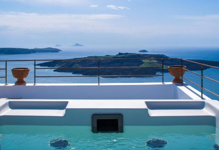 Amelot Art Suites gay-friendly hotel jacuzzi view. Santorini caldera backdrop. Luxury travel for gay men. Relaxing vacation.