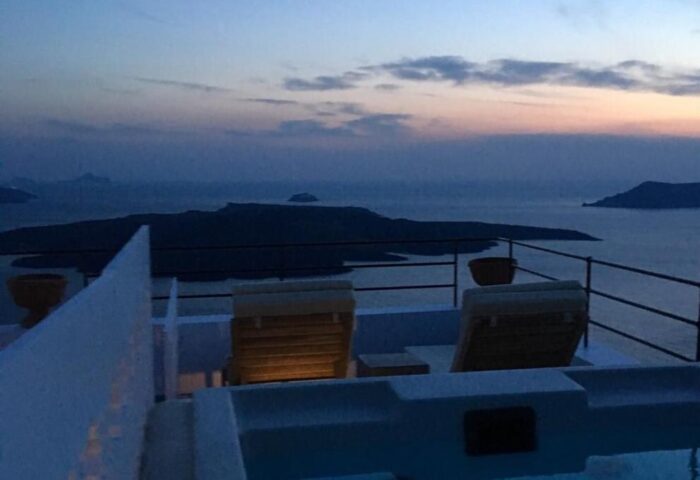 Amelot Art Suites gay-friendly hotel view. Jacuzzi and deck chairs overlook the sea at dusk. Ideal gay travel destination.