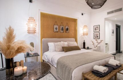 Amelot Art Suites gay-friendly hotel room. Stylish bedroom with double bed, bedside tables, and unique lighting. Gay travel advice.