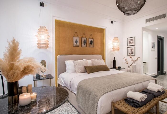 Amelot Art Suites gay-friendly hotel room. Stylish bedroom with double bed, bedside tables, and unique lighting. Gay travel advice.