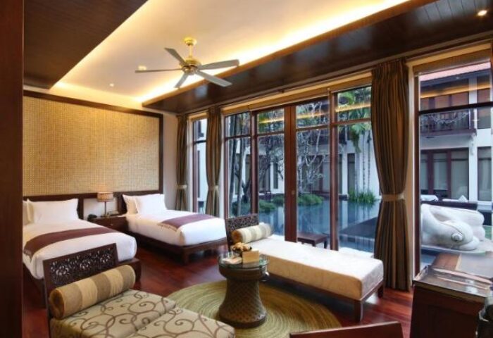 Anantara Angkor Resort room. Gay-friendly hotel with twin beds, seating, and a view of the pool. Luxury travel for gay men in Cambodia.