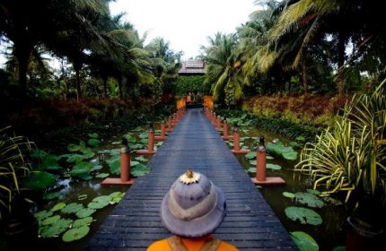 Anantara Bophut Koh Samui Resort wooden bridge. Gay-friendly hotel with tropical plants and water lilies. Ideal for gay men travel advice.