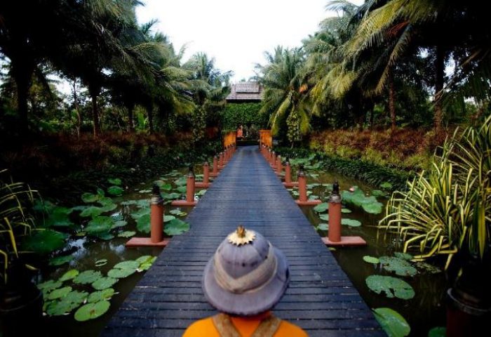 Anantara Bophut Koh Samui Resort wooden bridge. Gay-friendly hotel with tropical plants and water lilies. Ideal for gay men travel advice.