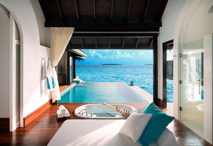 Gay-friendly Anantara Kihavah Maldives Villas interior. Bathtub, infinity pool, and ocean view. Luxury gay travel at its finest.