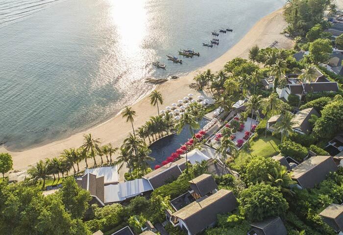 Aerial view of Anantara Lawana Koh Samui Resort, a gay-friendly hotel. Beachfront property with palm trees, pool, and ocean views. Thailand resort.